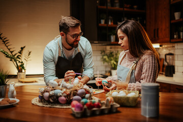 Couple enjoying creative easter egg painting activity