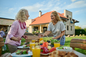 Happy family setting the table for lunch in the backyard
