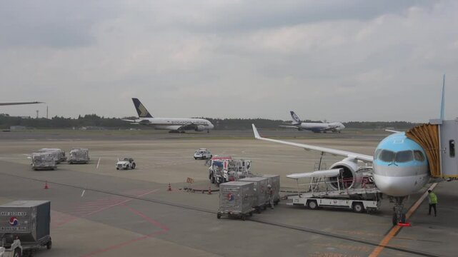 Korean Airlines airplane Airbus a220 arrived to Tokyo International Narita Airport. Ground Service is Working in Background. Singapore and Nippon Cargo Airlines Airplanes Are Taxing to Take Off
