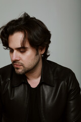 Obraz premium Portrait of bearded handsome man wearing black jacket. Vertical.