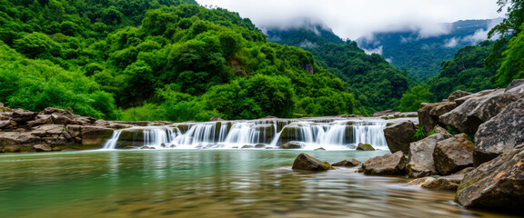 Fototapeta premium Calm waterfall flowing over rocks surrounded by a dense forest, exuding tranquility and natural beauty.