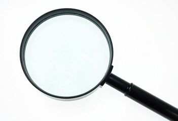 Magnifying glass with black handle isolated on white background. Macro closeup of transparent lens for investigation, search, discovery and exploration. Copy space for text.