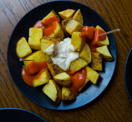 Spicy potatoes with garlic sauce and ketchup, Spanish dish Patatas bravas