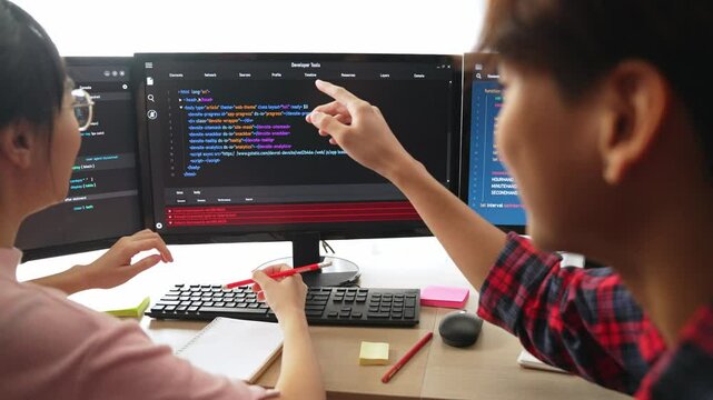 Slow motion back end software developer engineer for computer programming working together on debugging writing computing code, solving complex algorithms display on monitor in office. Burgeoning