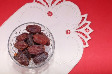 A bowl of dried dates, a traditional treat for breaking the fast during Ramadan, on a decorative...