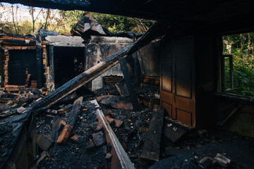 Fire aftermath. Burnt wooden house interior with remnant of furniture
