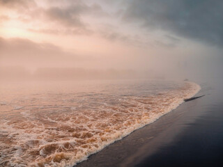 Water flowing through water dam in river Shannon, Athlone city, Ireland. Fog over water creates...
