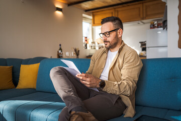 Adult man with eyeglasses read and watch document work at home