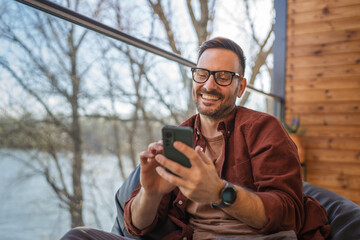 One adult man at home use smart phone app browse internet or send sms
