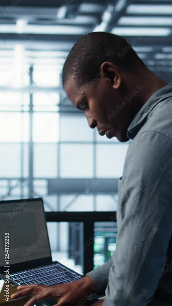 Poster vertical video engineer in data center operating notebook, deploying new server architectures. serve