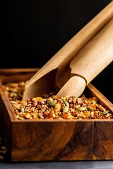 Close-up view of maple quinoa granola spilling from wooden bowl with scoop