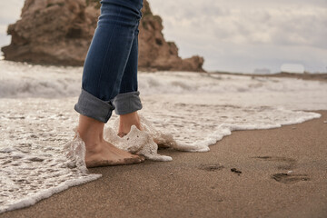 Feeling the Cool Ocean Waves Gently Lapping at Bare Feet on a Sunny Beach During a Tranquil Afternoon Stroll