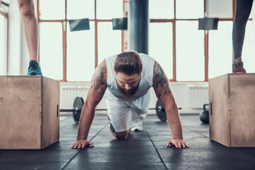 Sporty Man Doing Push Ups Between Two Athletes.