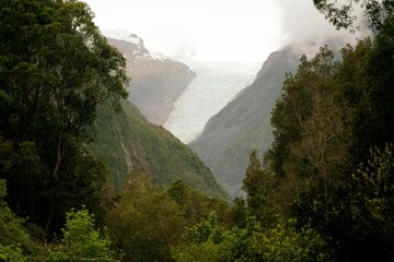 Fox Glacier Hiding in the Clouds Behind the Mountains – Mysterious Landscape of New Zealand’s...