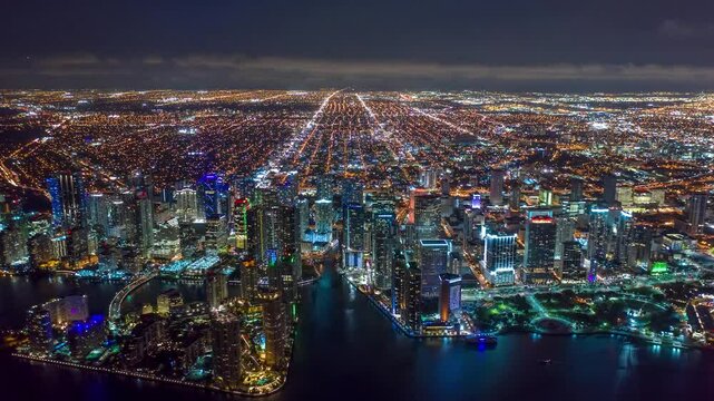 MIAMI, UNITED STATES - FEBRUARY 8, 2025: Aerial view of Miami skyline glowing at night with bright city lights over the water
