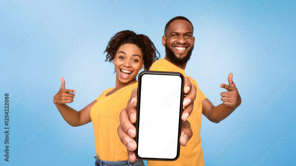 Poster check this out, cellphone display mockup. positive african american couple pointing at cellphone wit