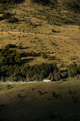 Naklejka premium A car drives through the mountains.