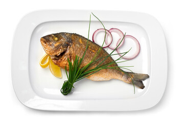grilled fish on a plate with onions and lemon