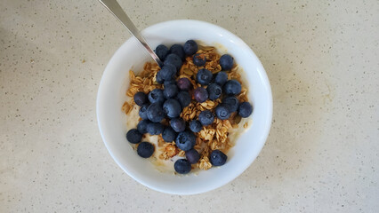 Healthy Bowl of yogurt with granola topped with fresh blueberries