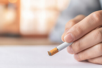 Quitting smoking according to the concept of drug addiction treatment. close up of hand holding cigarette, symbolizing moment of contemplation
