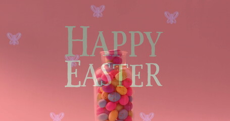 Fototapeta premium Image of happy easter text over colourful eggs in jar on pink background