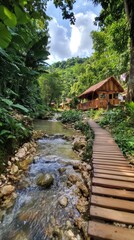 Wooden walkway beside a stream in a tropical valley