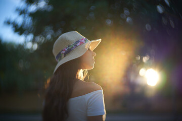 Golden Hour Captures Serenity as a Woman in a Sun Hat Gazes Towards a Glowing Sunset Surrounded by...
