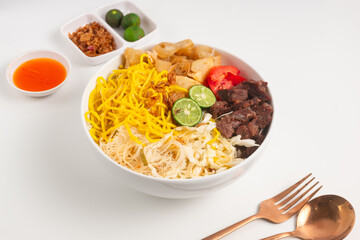 Soto Mie Bogor. Traditional Sundanese Beef Noodle Soup with Spring Roll, Cabbage, and Tomato. Street Food from Bogor, West Java, Indonesia. Perfect for recipe, article, catalogue.