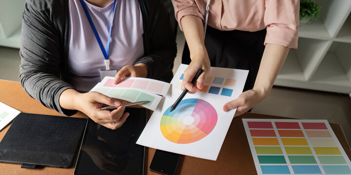 Graphic design team reviewing color palettes and materials in a creative workspace.