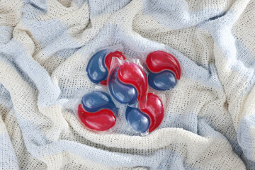 Laundry detergent capsules on color fabric, top view