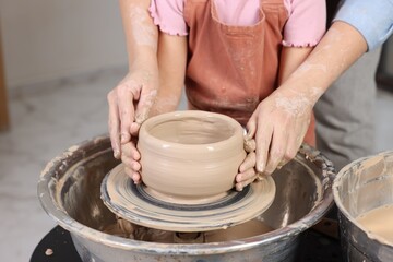 Hobby and craft. Daughter with her mother making pottery indoors, closeup