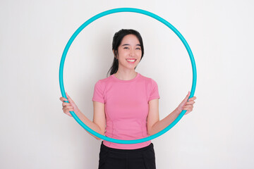 A women in sportswear smiling happy while holding a hula hoop