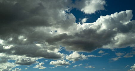 Sun shining through the puffy clouds. Sky view. Beautiful sunny sky. Background with clouds on blue...