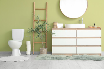 Interior of restroom with toilet bowl, sink and mirror