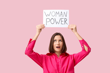 Beautiful young woman holding WOMAN POWER sign on pink background. Women's history month