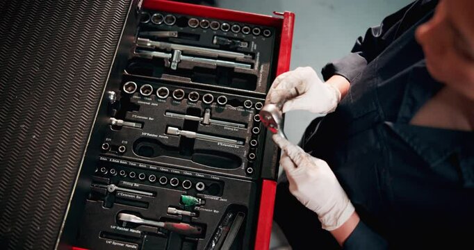 Above mechanic, toolbox and hands with tools in garage for maintenance, repair service and engine fixing. Motor industry, person and ratchet spanner in workshop for auto inspection and examine car