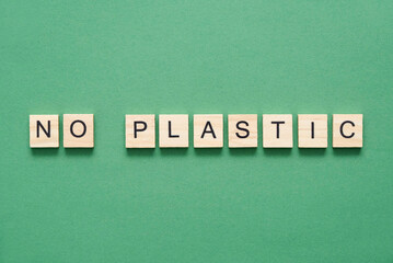 Wood pieces with letters form a message of sustainability: no plastic