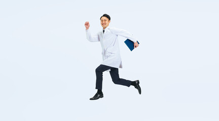 ジャンプする白衣を着たミドル男性の全身写真　医師　科学者　研究者（切り抜き背景透過PNGも販売しております。作成者リンクから「PNG」で検索してください）