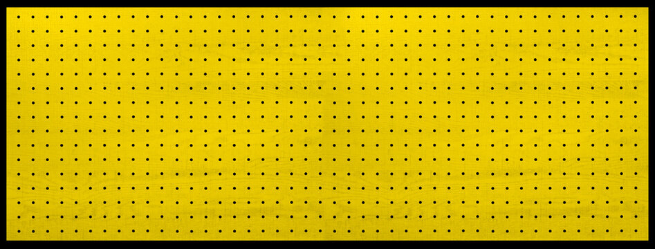 黄色くペイントされた、木製の有孔ボード。
peg board