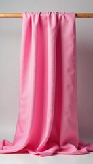 Fototapeta premium Elegant pink silk fabric draped over a wooden dowel, flowing, organic