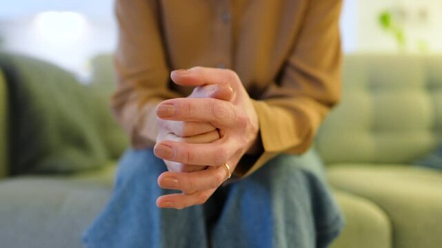 Nervous woman clasped hands anxiously twisting fingers awaiting uncertain news on hospital couch. High levels of stress, uncertainty and emotional crisis during therapy session or personal struggle