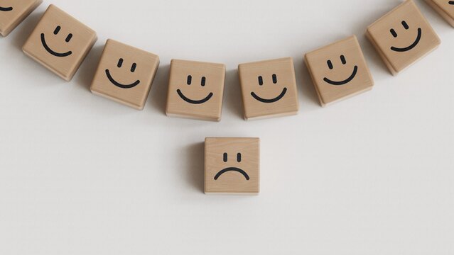 Sad smile against happy smiles on wooden blocks. Depression, mental health. Top view.Facial expressions. Mental health assessment.3D rendering on white background.
