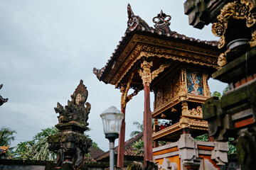 Naklejka premium This image captures a beautifully crafted Balinese temple structure, intricately decorated with gold accents and traditional carvings.