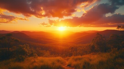 Obraz premium Fiery sunset over mountain range, grassy vista
