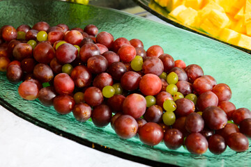 Red and green grapes in a green plate