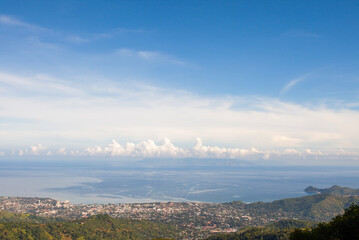 Fototapeta premium A beautiful view of Dili, the capital of East Timor, seen from a hill on the outskirts of the city. In the distance, the Cristo Rei statue, the icon of Dili, is visible.