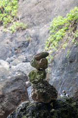 Stacked rocks from the waterfall Island near Nusa Penida. The act of balancing stones against gravity in Nature crearing a natural sculpture.