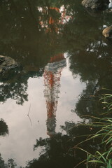 A reflection on the lake surface, blending architecture and nature in a tranquil scene with gentle ripples.