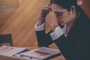 Businesswoman suffering headache from business disappointed and seriously by bad business results.