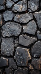 Dark stone surface with visible cracks and texture in a close up view showing details